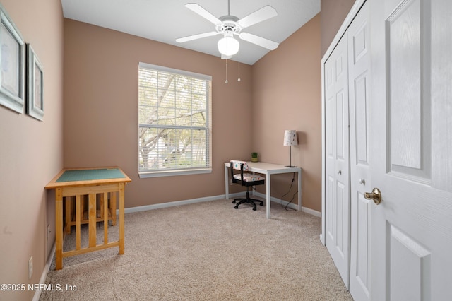 carpeted office space featuring baseboards and ceiling fan