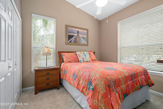 bedroom featuring lofted ceiling, carpet flooring, baseboards, ceiling fan, and a closet