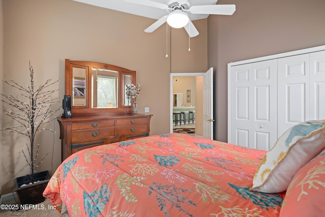 bedroom with a closet, ceiling fan, and a towering ceiling
