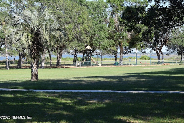 view of property's community with a lawn and playground community