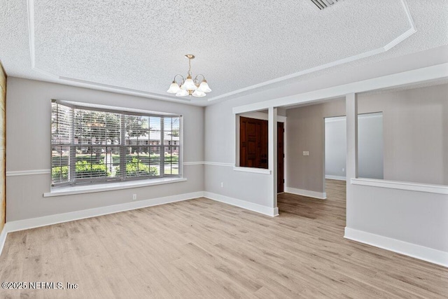 1967 Sussex Dr S, Orange Park, FL 32073 - unfurnished room with baseboards, a textured ceiling, wood finished floors, and a notable chandelier