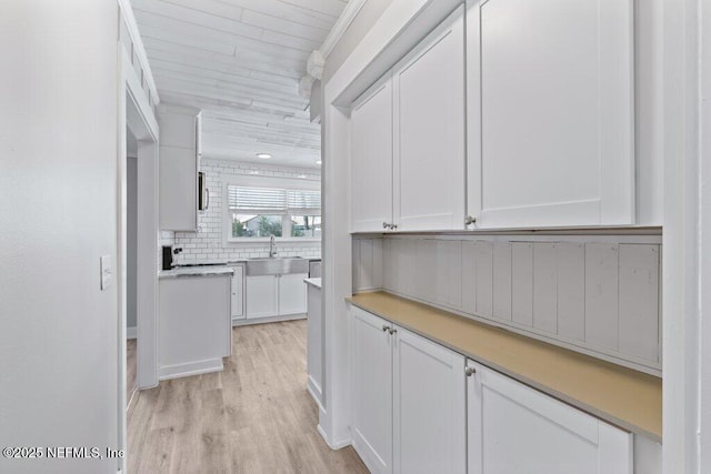 1967 Sussex Dr S, Orange Park, FL 32073 - interior space featuring light countertops, a sink, tasteful backsplash, light wood-style flooring, and white cabinets