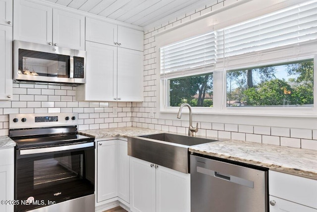 1967 Sussex Dr S, Orange Park, FL 32073 - kitchen featuring backsplash, a sink, white cabinetry, and appliances with stainless steel finishes