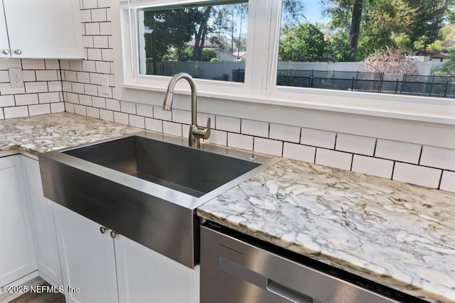 1967 Sussex Dr S, Orange Park, FL 32073 - kitchen with dishwasher, light stone countertops, tasteful backsplash, white cabinetry, and a sink