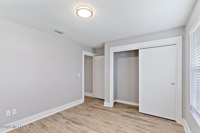 1967 Sussex Dr S, Orange Park, FL 32073 - unfurnished bedroom featuring baseboards, light wood-type flooring, a closet, and a textured ceiling