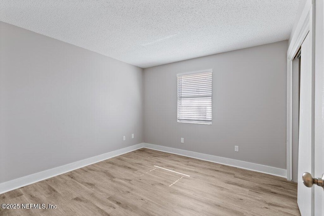 1967 Sussex Dr S, Orange Park, FL 32073 - unfurnished bedroom featuring baseboards, a textured ceiling, a closet, and light wood finished floors