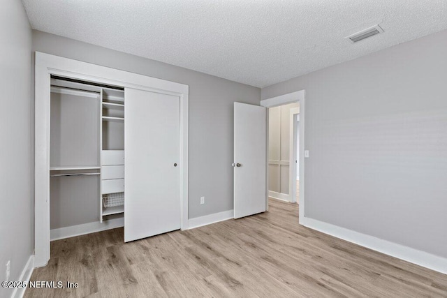 1967 Sussex Dr S, Orange Park, FL 32073 - unfurnished bedroom with a closet, a textured ceiling, visible vents, baseboards, and wood finished floors