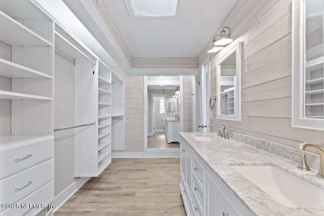 1967 Sussex Dr S, Orange Park, FL 32073 - bathroom with double vanity, a sink, wood finished floors, and wood walls