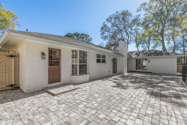 1967 Sussex Dr S, Orange Park, FL 32073 - back of property with a chimney, a patio area, and brick siding