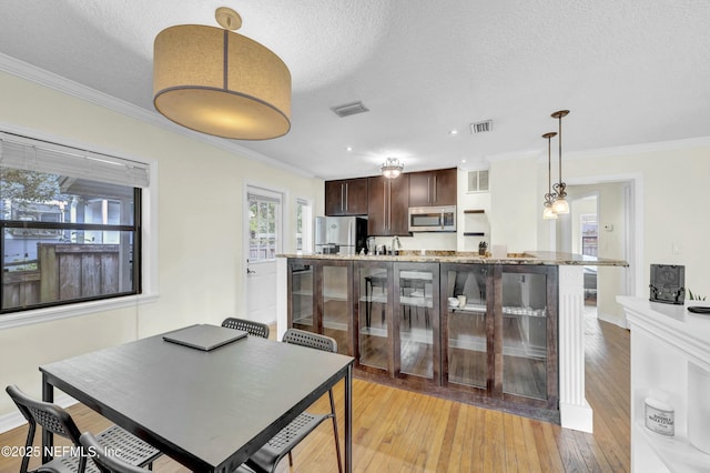 4817 Kerle St, Jacksonville, FL 32205 - dining area with light wood finished floors, visible vents, crown molding, and a textured ceiling