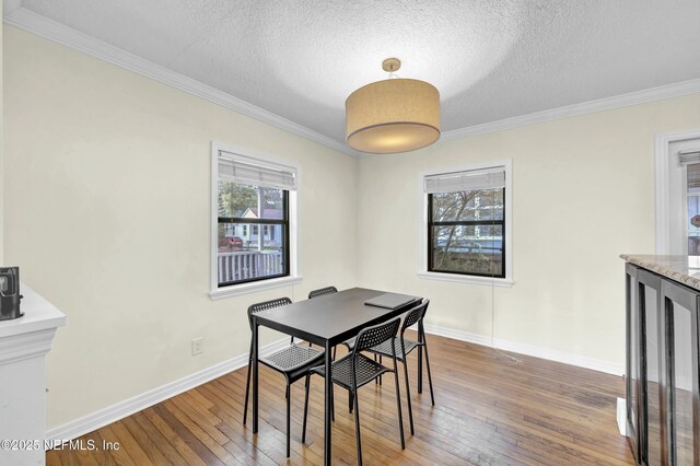 4817 Kerle St, Jacksonville, FL 32205 - dining room with baseboards, crown molding, a textured ceiling, and wood-type flooring