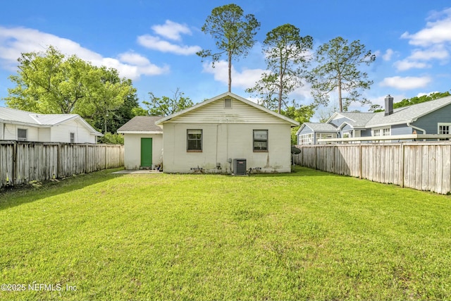 4817 Kerle St, Jacksonville, FL 32205 - back of house with a fenced backyard, a lawn, and central AC