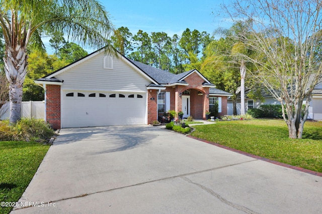 single story home featuring concrete driveway, fence, an attached garage, a front yard, and brick siding