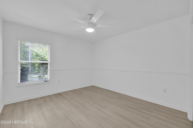 unfurnished room featuring baseboards, wood finished floors, and ceiling fan