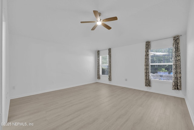 empty room with plenty of natural light, baseboards, light wood-style floors, and a ceiling fan