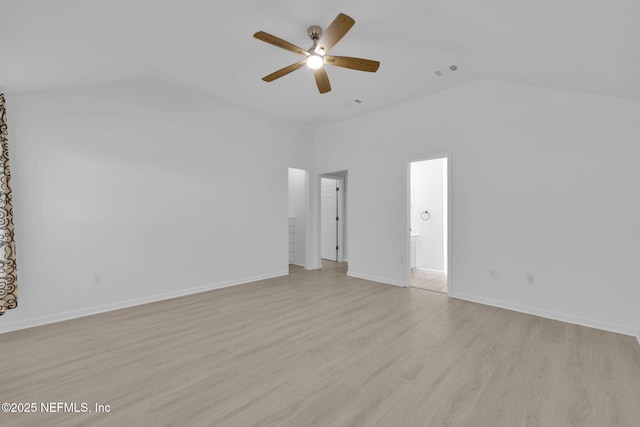 empty room with vaulted ceiling, baseboards, light wood-style floors, visible vents, and a ceiling fan