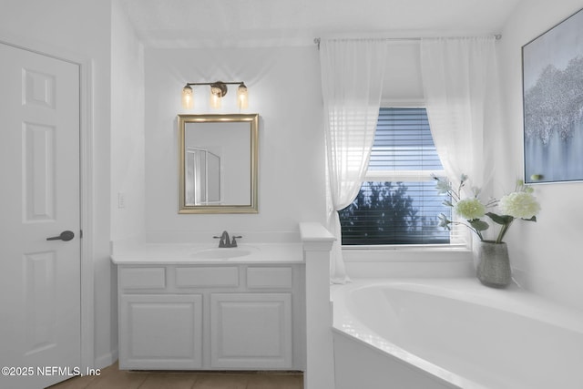 bathroom featuring tile patterned floors, vanity, and a bath