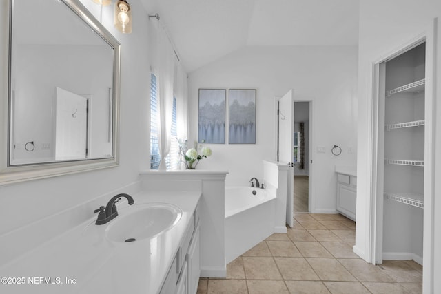 full bathroom with lofted ceiling, a garden tub, tile patterned flooring, and vanity