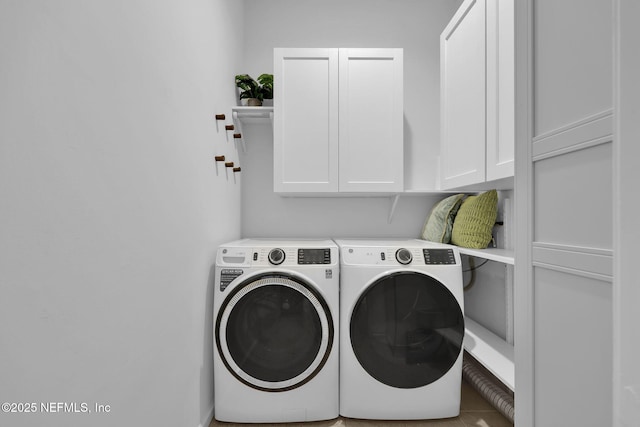 laundry room with washing machine and clothes dryer and cabinet space