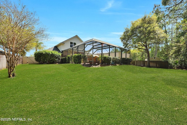 view of yard featuring a fenced backyard and a lanai