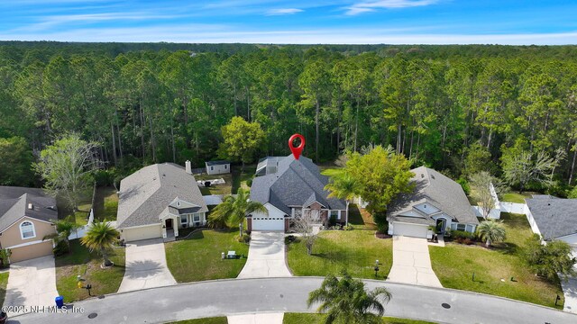 drone / aerial view featuring a residential view and a forest view