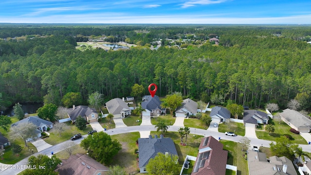drone / aerial view with a water view, a wooded view, and a residential view
