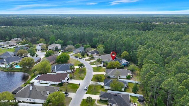 birds eye view of property featuring a water view, a view of trees, and a residential view