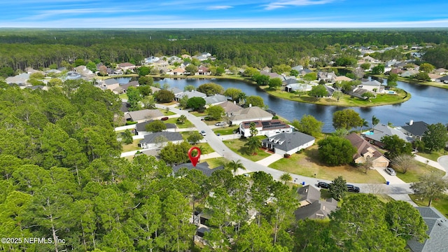 aerial view featuring a forest view, a residential view, and a water view