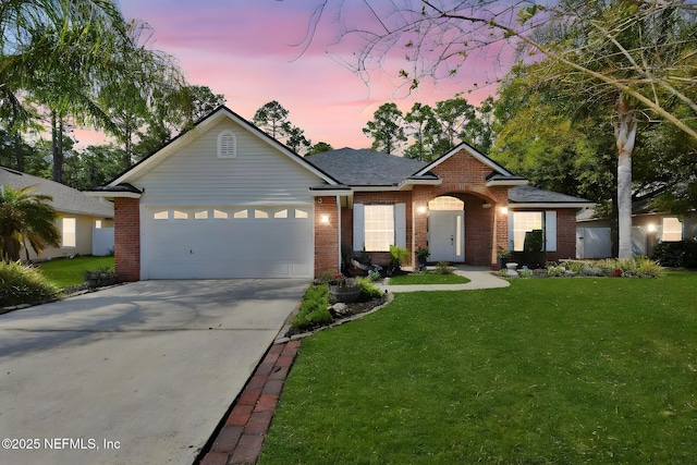 ranch-style house with a lawn, an attached garage, brick siding, and concrete driveway