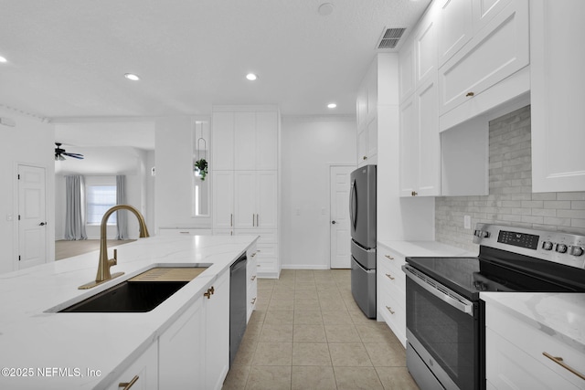 kitchen featuring visible vents, stainless steel appliances, white cabinetry, a sink, and backsplash