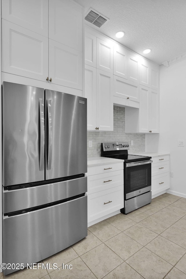 kitchen with white cabinetry, light countertops, backsplash, visible vents, and appliances with stainless steel finishes