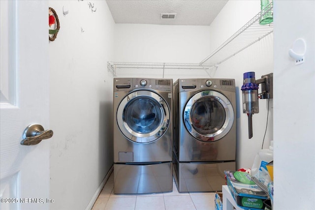 clothes washing area featuring visible vents, laundry area, a textured ceiling, independent washer and dryer, and tile patterned flooring