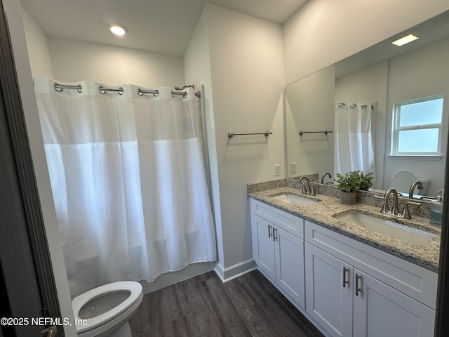 bathroom with toilet, shower / bath combination with curtain, wood finished floors, and a sink