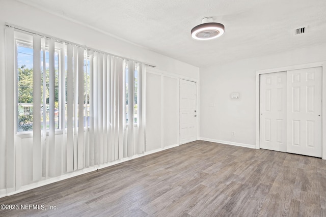 3838 Winton Dr, Jacksonville, FL 32208 - unfurnished bedroom with baseboards, visible vents, wood finished floors, and a textured ceiling