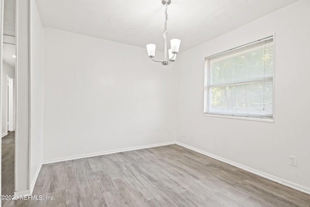 3838 Winton Dr, Jacksonville, FL 32208 - empty room featuring baseboards, wood finished floors, and an inviting chandelier