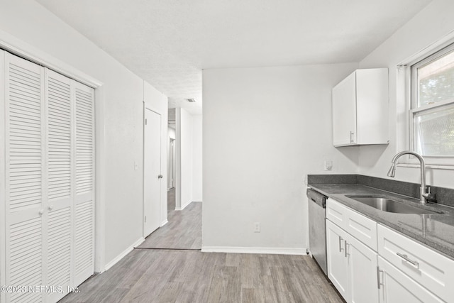 3838 Winton Dr, Jacksonville, FL 32208 - kitchen featuring white cabinetry, light wood-style flooring, a sink, and dishwasher