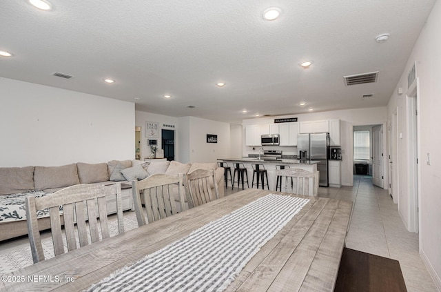 dining space featuring light tile patterned flooring, visible vents, and recessed lighting