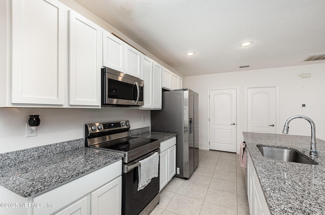 kitchen with stone counters, appliances with stainless steel finishes, a sink, and visible vents