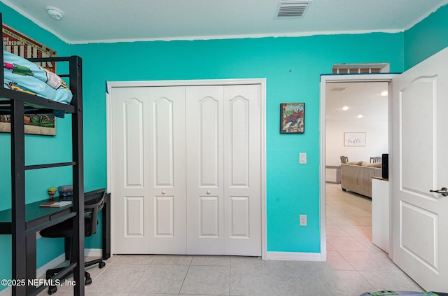 bedroom featuring light tile patterned floors, baseboards, a closet, and visible vents