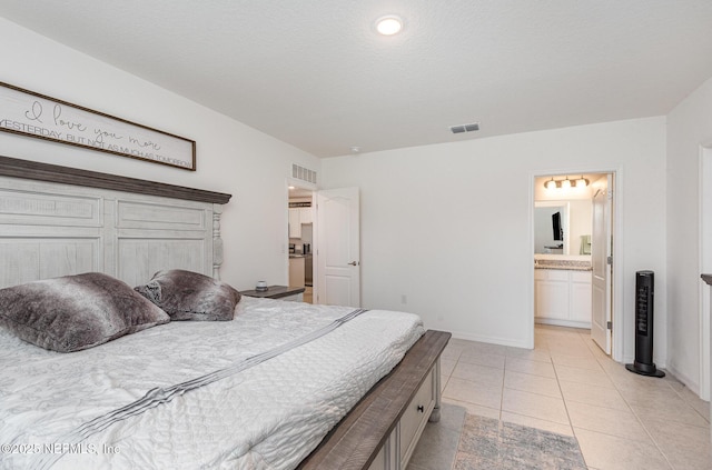 bedroom featuring light tile patterned floors, baseboards, ensuite bath, and visible vents