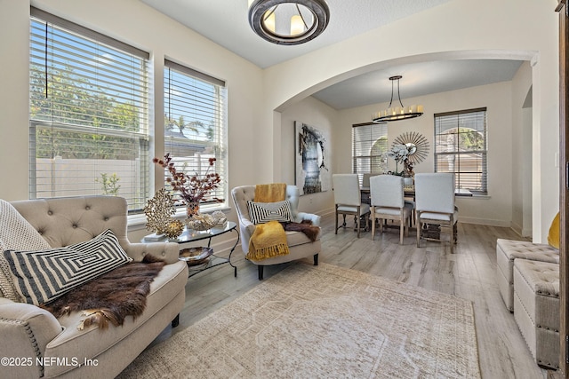 110 Arabian Ct, Saint Augustine, FL 32095 - sitting room with baseboards, wood finished floors, arched walkways, and an inviting chandelier