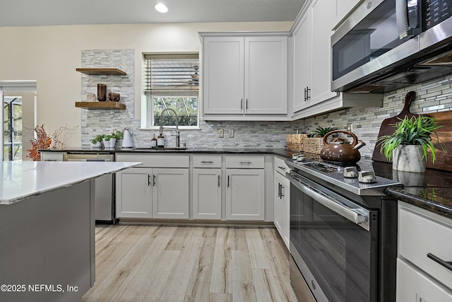 110 Arabian Ct, Saint Augustine, FL 32095 - kitchen with open shelves, backsplash, a sink, light wood finished floors, and appliances with stainless steel finishes