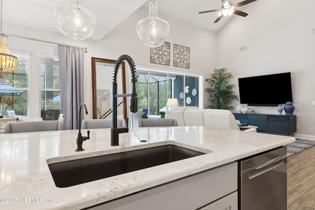 64 Whirlaway Ct, Saint Johns, FL 32259 - kitchen with open floor plan, a sink, wood finished floors, light stone countertops, and dishwasher
