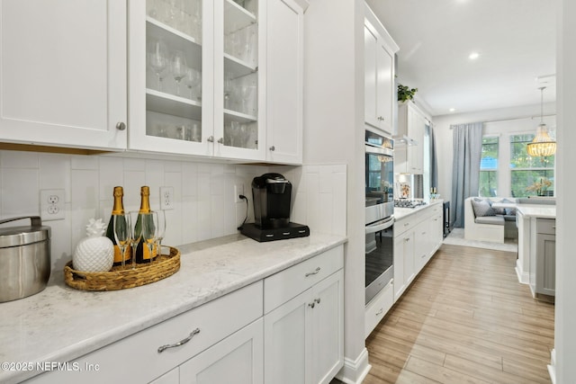 64 Whirlaway Ct, Saint Johns, FL 32259 - kitchen featuring white cabinetry, backsplash, glass insert cabinets, and recessed lighting