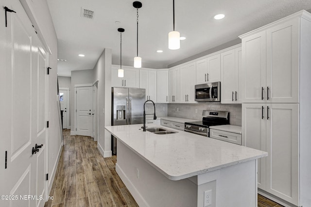 335 5th Ave S, Jacksonville Beach, FL 32250 - kitchen featuring tasteful backsplash, light wood-type flooring, stainless steel appliances, a sink, and visible vents