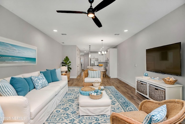 335 5th Ave S, Jacksonville Beach, FL 32250 - living room with baseboards, visible vents, ceiling fan with notable chandelier, and light wood finished floors