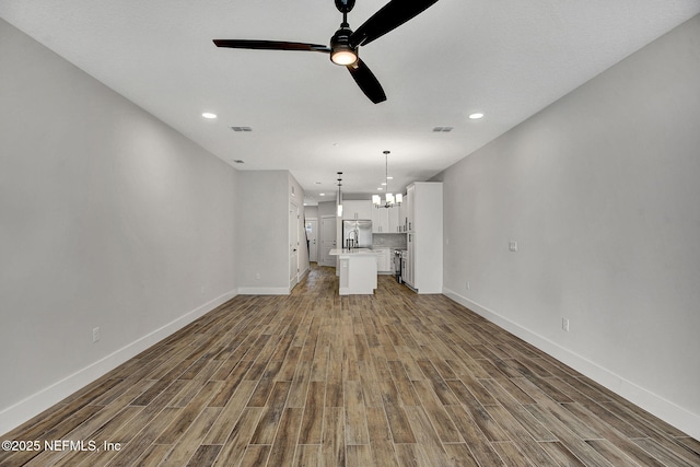 335 5th Ave S, Jacksonville Beach, FL 32250 - unfurnished living room featuring a sink, wood finished floors, baseboards, ceiling fan with notable chandelier, and visible vents