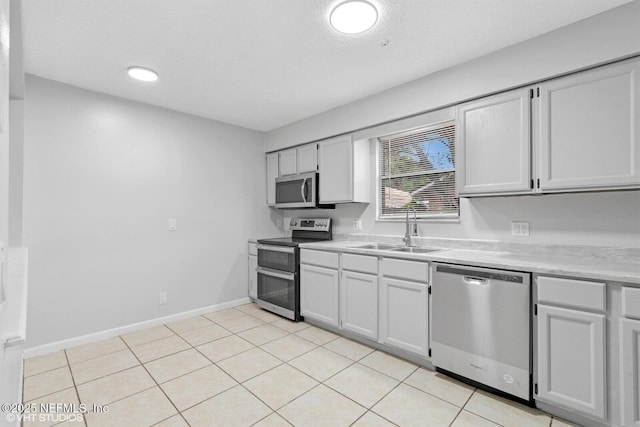 7927 Dwyer Dr, Jacksonville, FL 32244 - kitchen with light tile patterned flooring, light countertops, a sink, stainless steel appliances, and baseboards