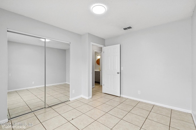 7927 Dwyer Dr, Jacksonville, FL 32244 - unfurnished bedroom featuring baseboards, a textured ceiling, light tile patterned flooring, visible vents, and a closet