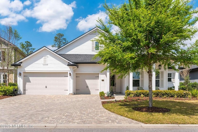 126 Seahill Dr, Saint Augustine, FL 32092 - view of front facade featuring an attached garage, a front lawn, roof with shingles, and decorative driveway